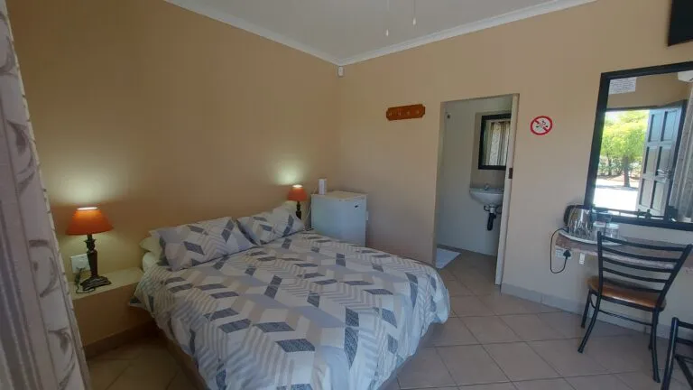 Bedroom with double bed nightstand lamp and attached bathroom