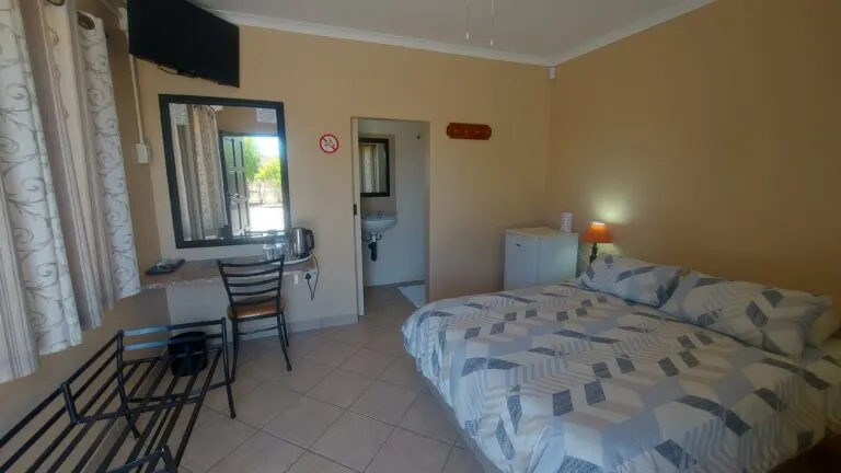 Bedroom with double bed desk chair and ensuite bathroom entrance