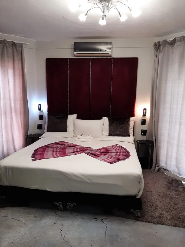 Modern bedroom with a large bed red headboard and sheer curtains