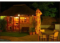 Cozy outdoor seating area with a thatchedroof building at night