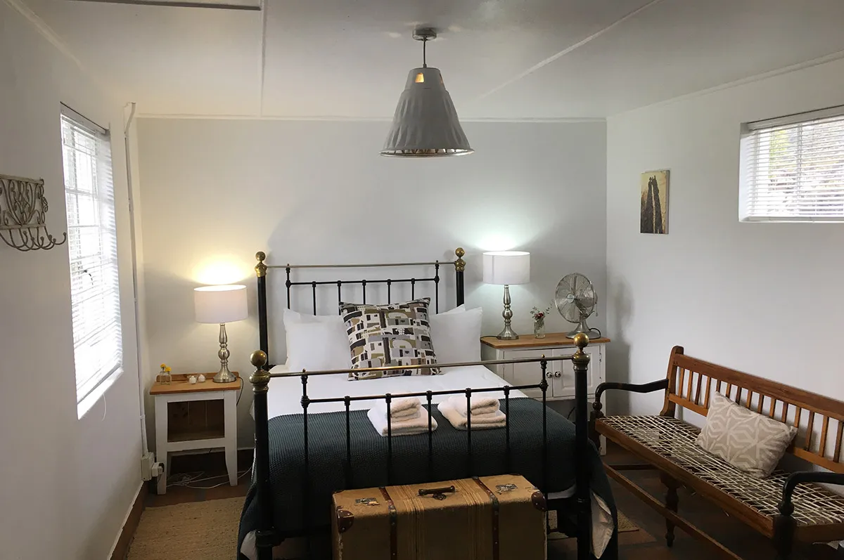 Cozy bedroom with a bed bench and bedside tables with lamps