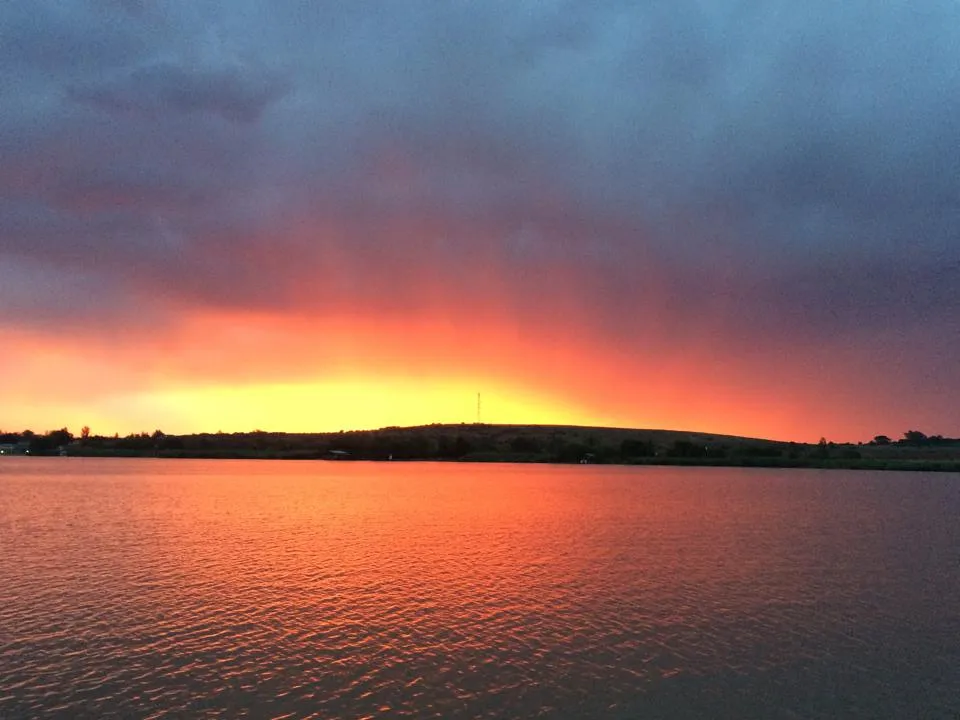 Sunset over a lake with vibrant orange and purple sky