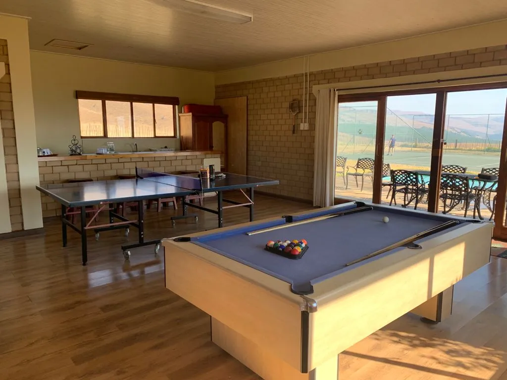 Pool table in a room with a ping pong table and outdoor view