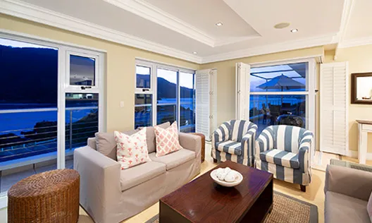 Modern living room with large windows striped chairs and ocean view
