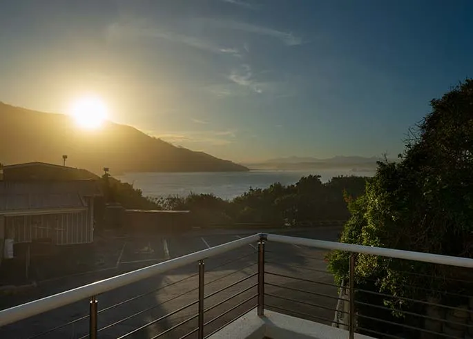 Sunset view from a balcony overlooking mountains and water