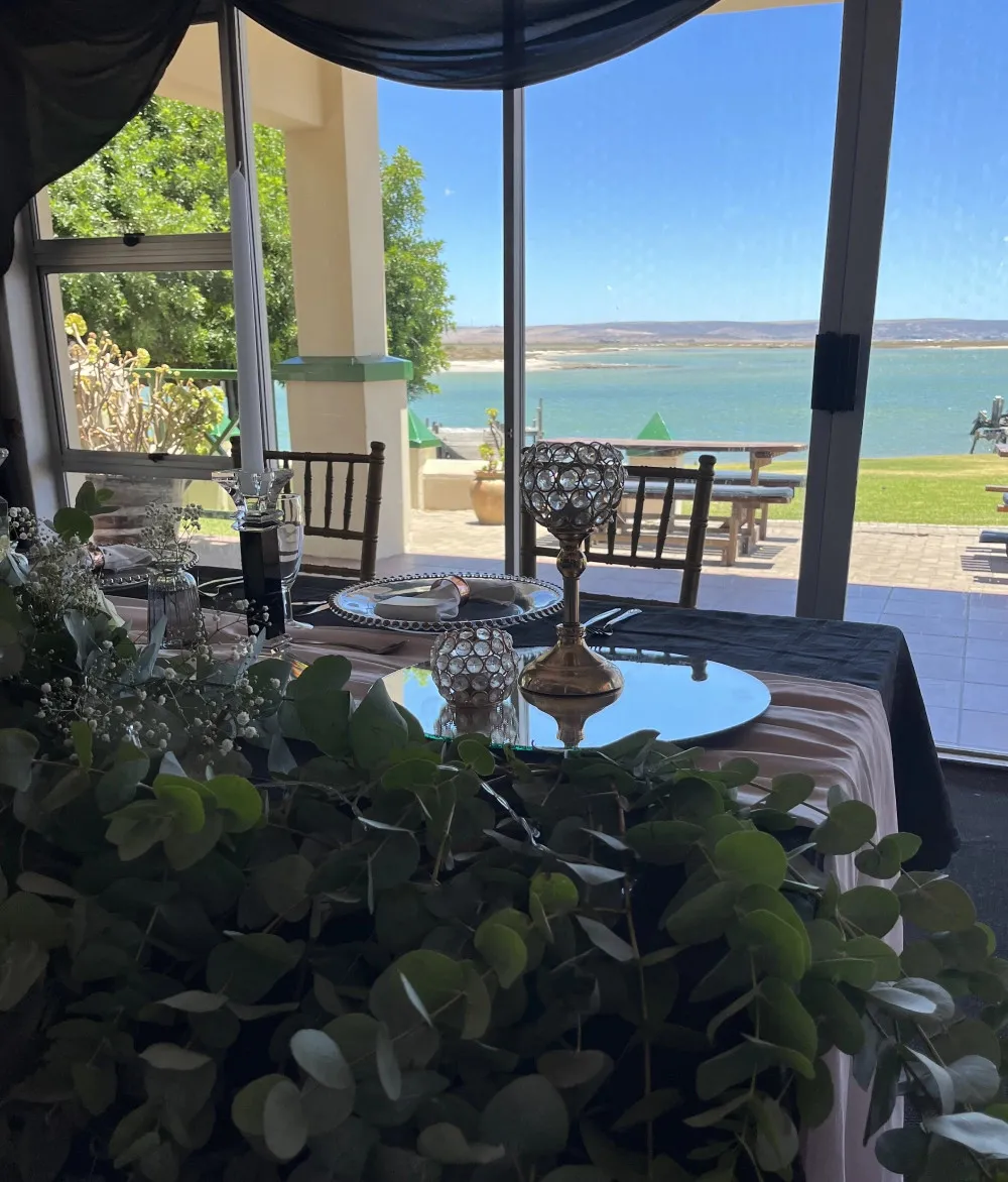 Elegant table setting with view of lake and greenery through large windows