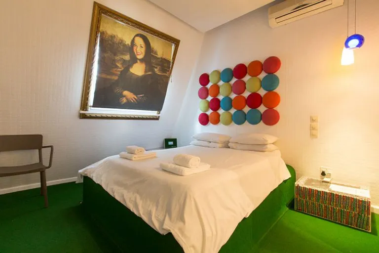 Bedroom with a bed colorful wall art and a large framed painting above