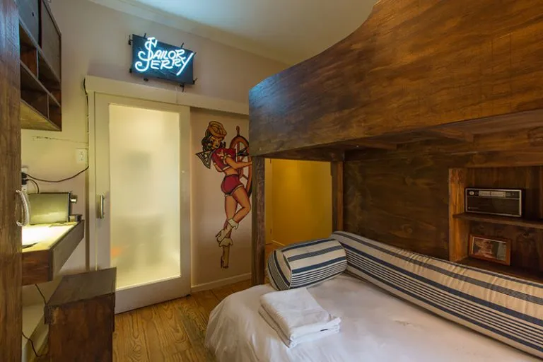 Wooden bunk bed in a cozy room with a neon sign and retro decor