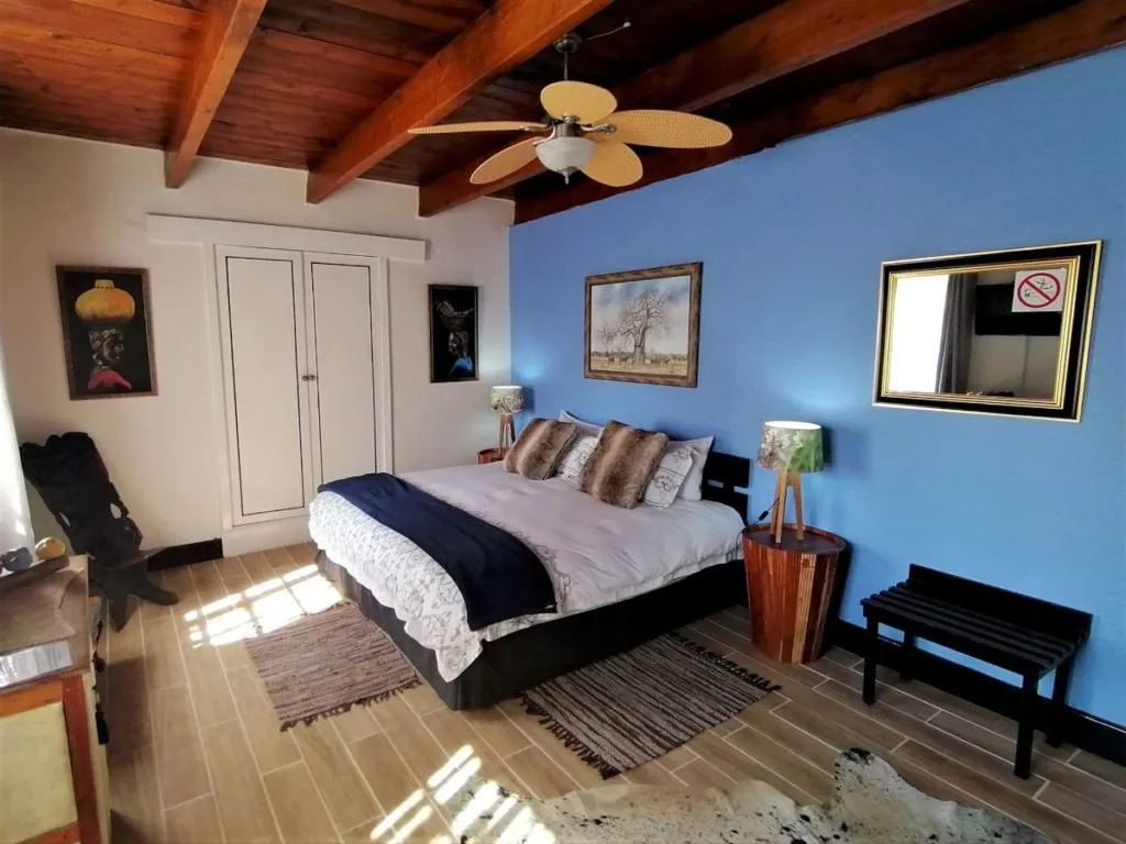 Cozy bedroom with a bed wooden ceiling blue walls and various decor items