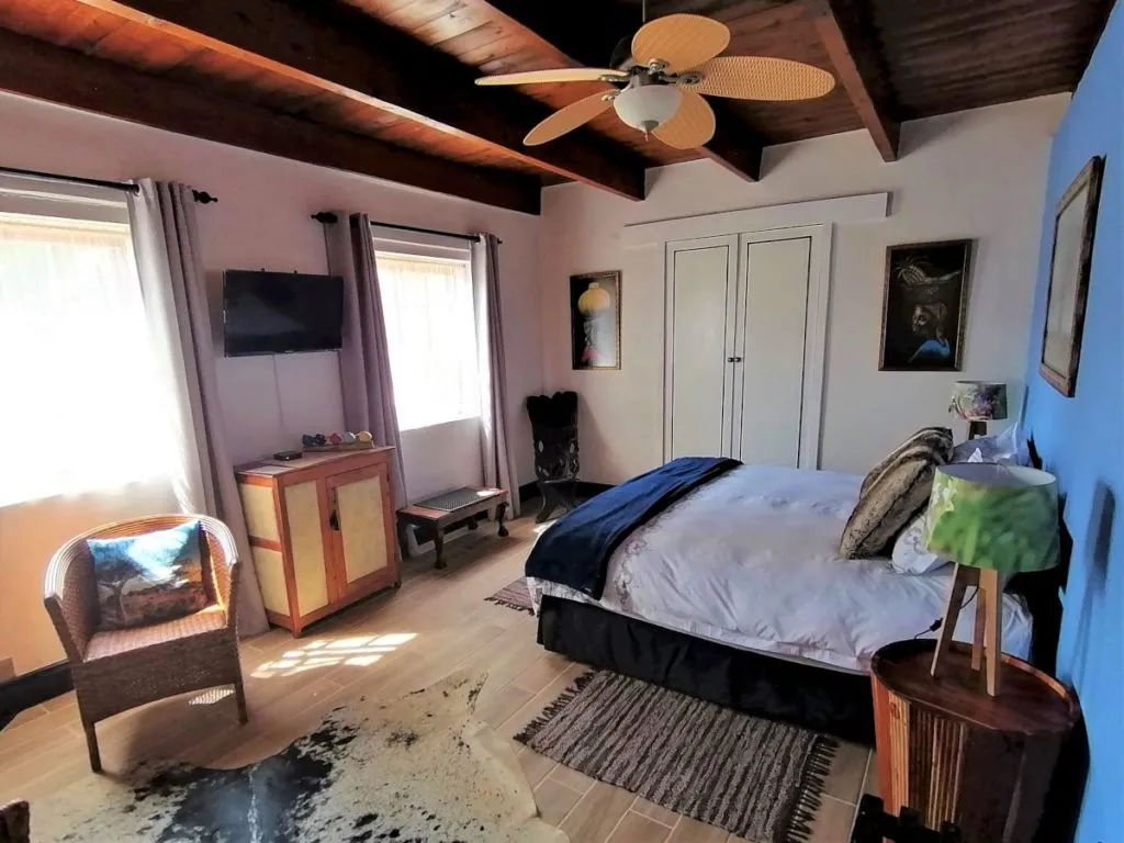 Cozy bedroom with wooden ceiling large bed and various furniture pieces