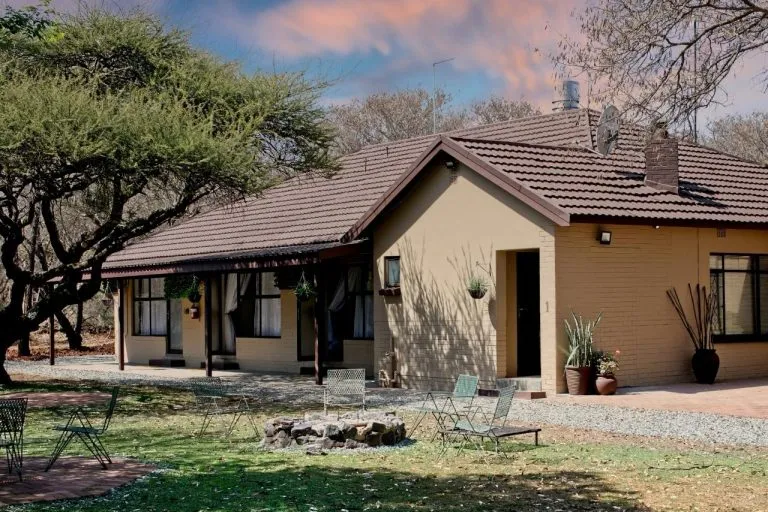 Singlestory house with a tiled roof garden and outdoor seating area