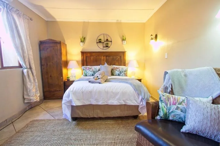 Cozy bedroom with a large bed nightstand lamps and a couch