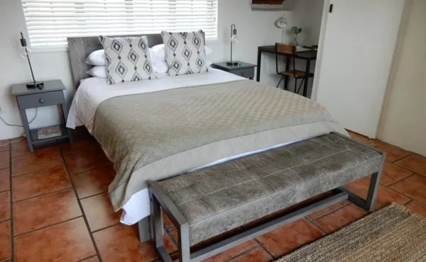 Modern bedroom with a bed bench and tiled floor