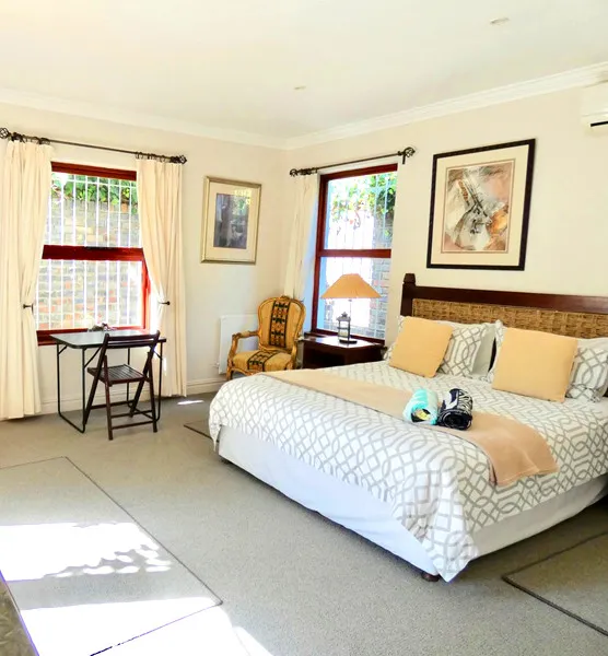 Cozy bedroom with large bed side table chair and framed artwork on walls