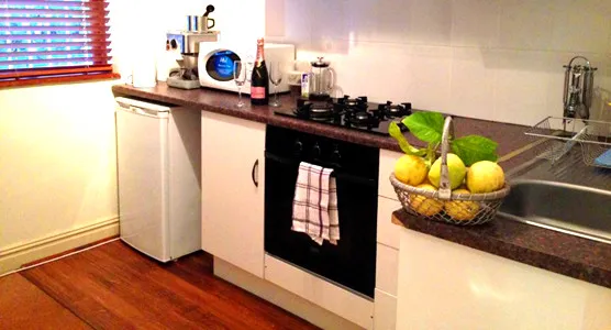 Modern kitchen with white cabinets black appliances and a basket of lemons