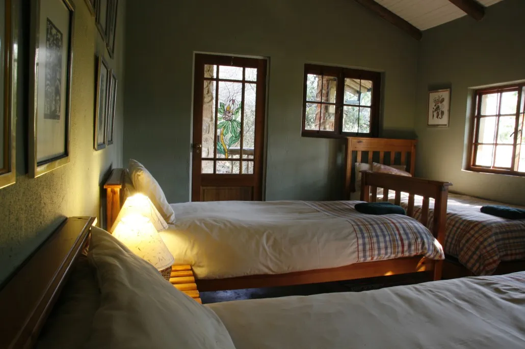 Cozy bedroom with two beds wooden furniture and framed pictures on the wall