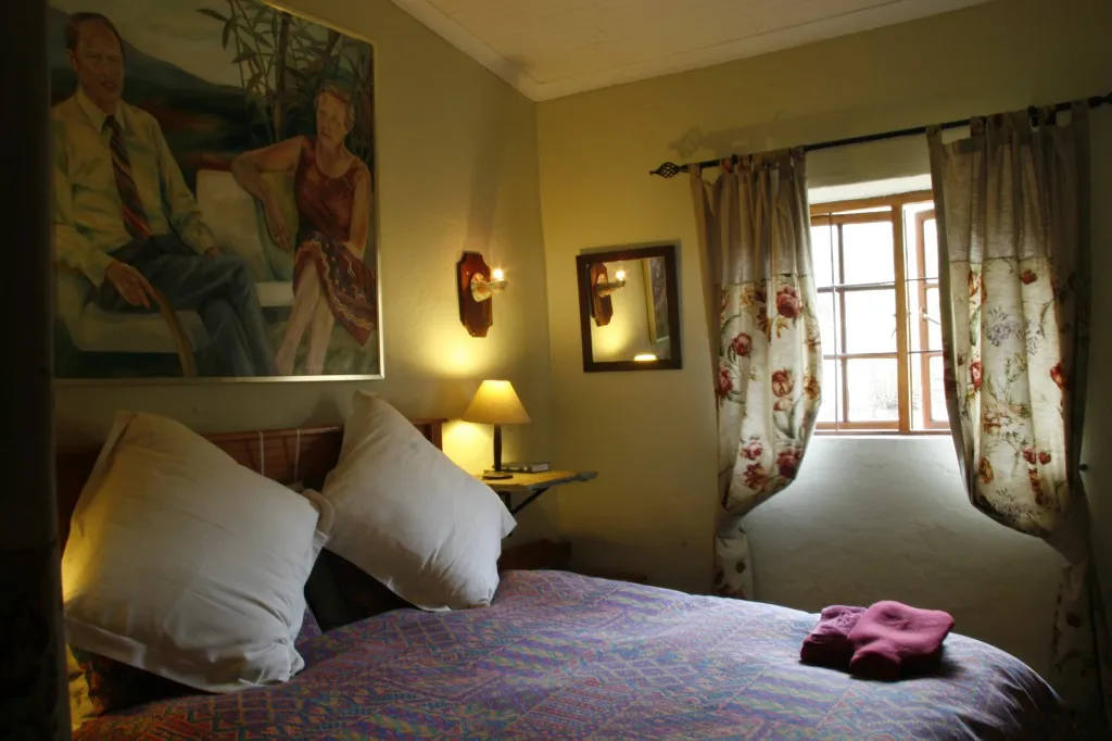 Cozy bedroom with a bed painting mirror and floral curtains on a window