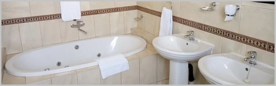 Modern bathroom with a large bathtub two sinks and tiled walls