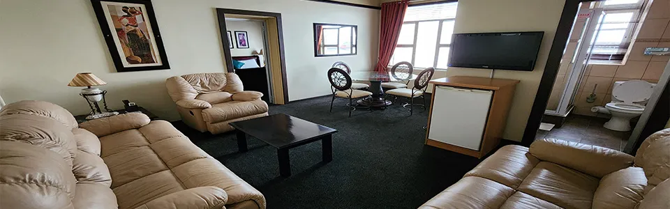 Living room with sofas coffee table dining area TV and visible bathroom