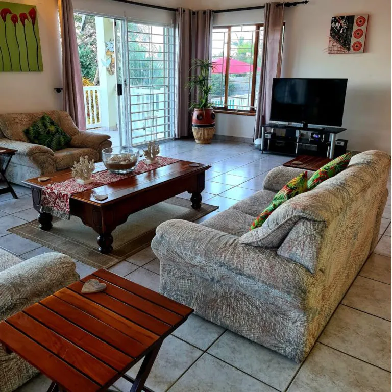 Living room with sofa coffee table TV and sliding glass doors to patio