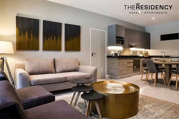 Modern living room with sofa tables and kitchen area in background