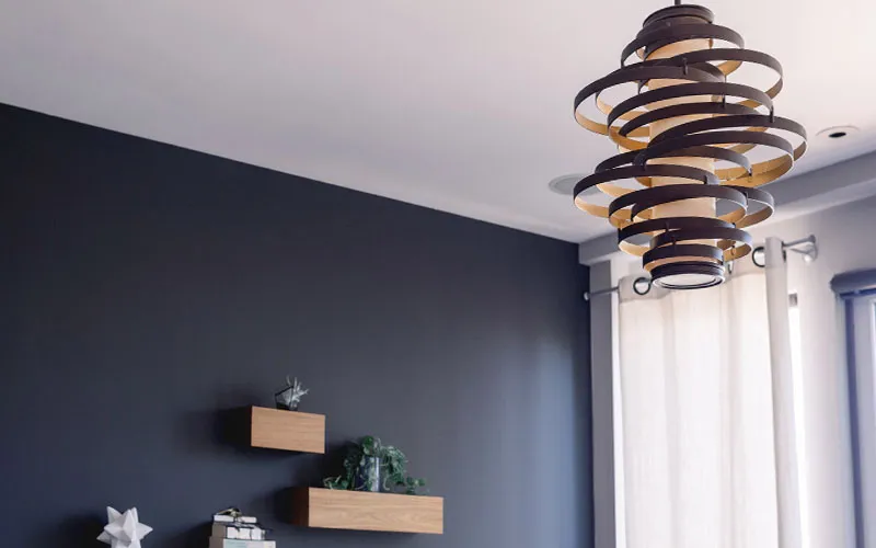 Modern hanging light fixture in a stylish darkcolored room with shelves and curtains