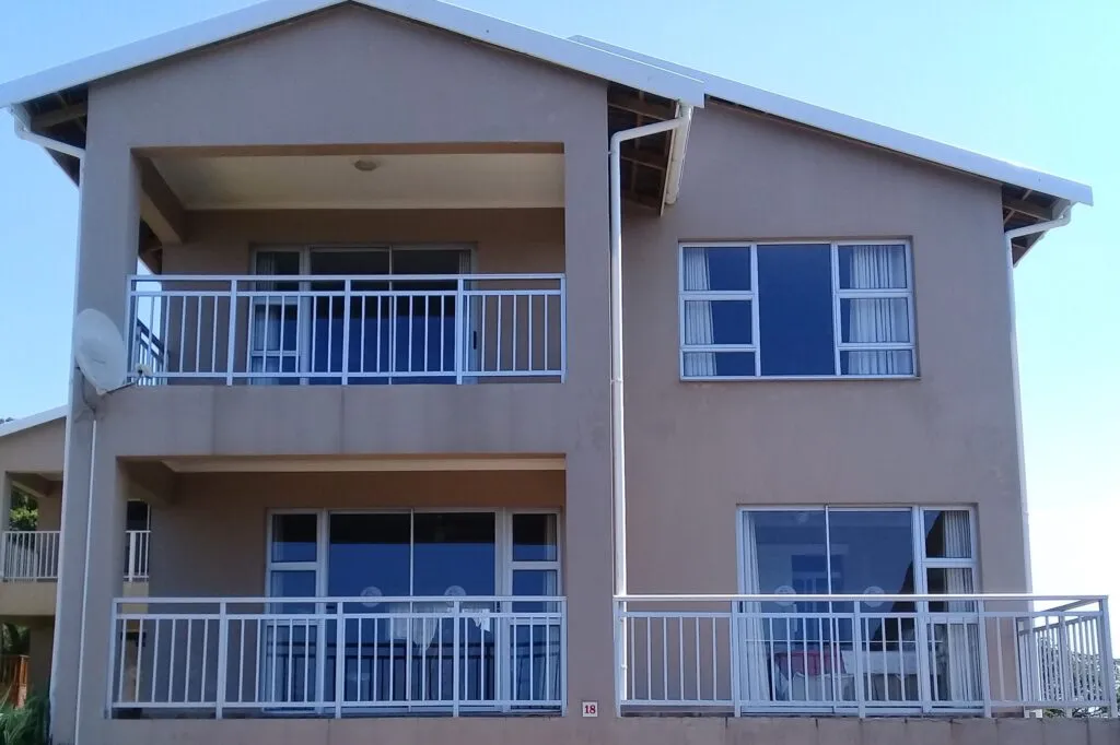 Twostory house with balconies large windows and a satellite dish on the wall