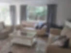 Blurred living room with sofas coffee table and large windows