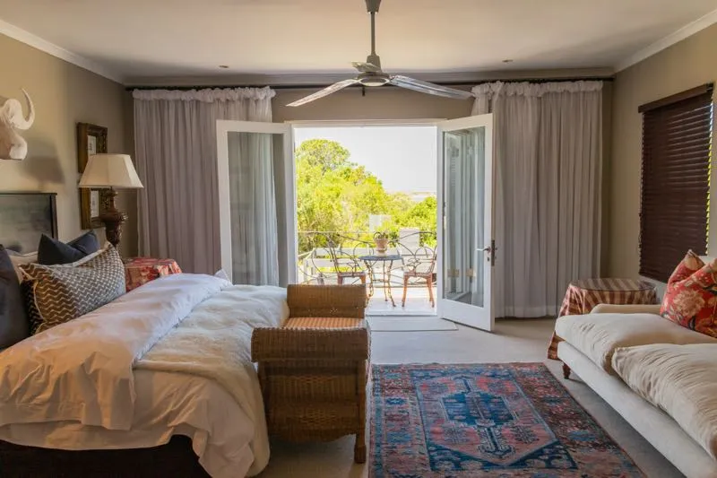 Bedroom with open doors to a patio large bed and sofa