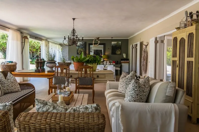 Cozy living room with rustic furniture plants and open windows to garden view