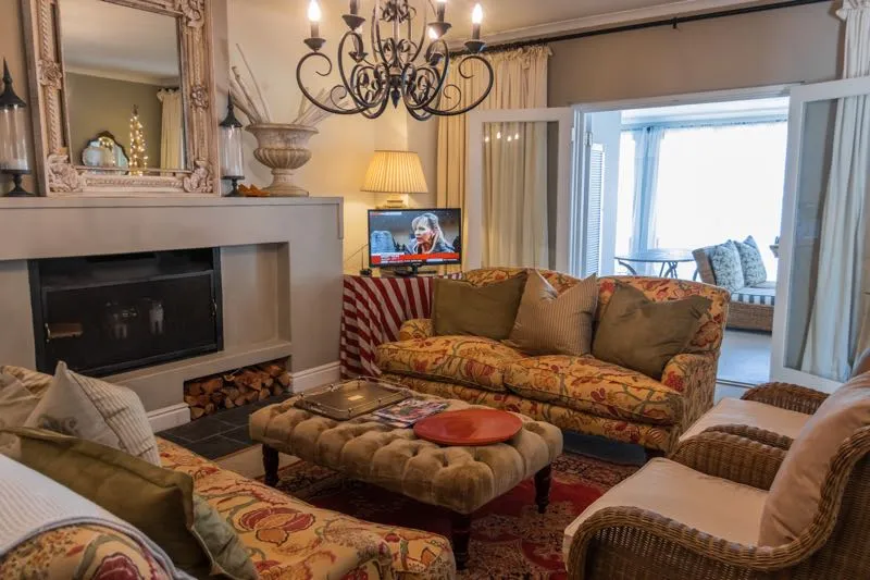 Cozy living room with floral furniture fireplace and large windows