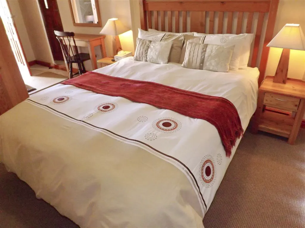 Cozy bedroom with a large bed wooden headboard and bedside tables with lamps