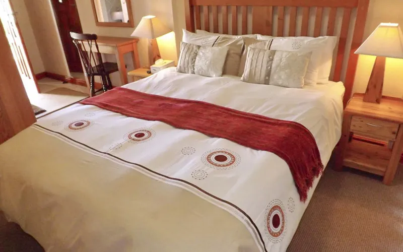 Cozy bedroom with a large bed wooden furniture and warm lighting