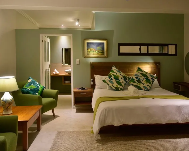Cozy bedroom with green walls large bed and green patterned pillows