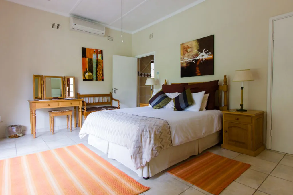 Cozy bedroom with a large bed wooden furniture and colorful decor