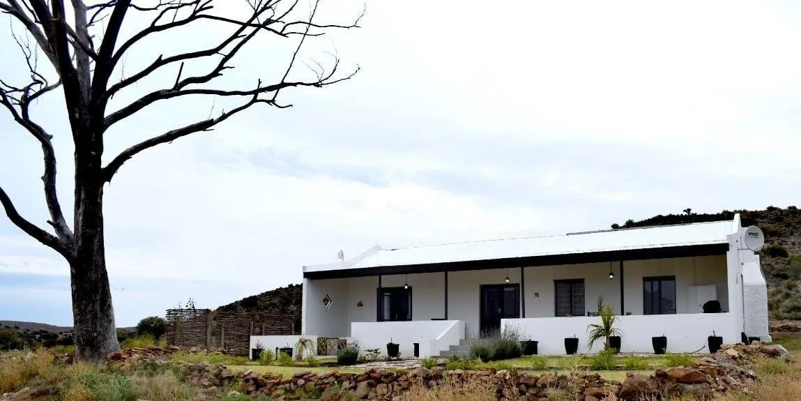 White house with a tree in a rural setting