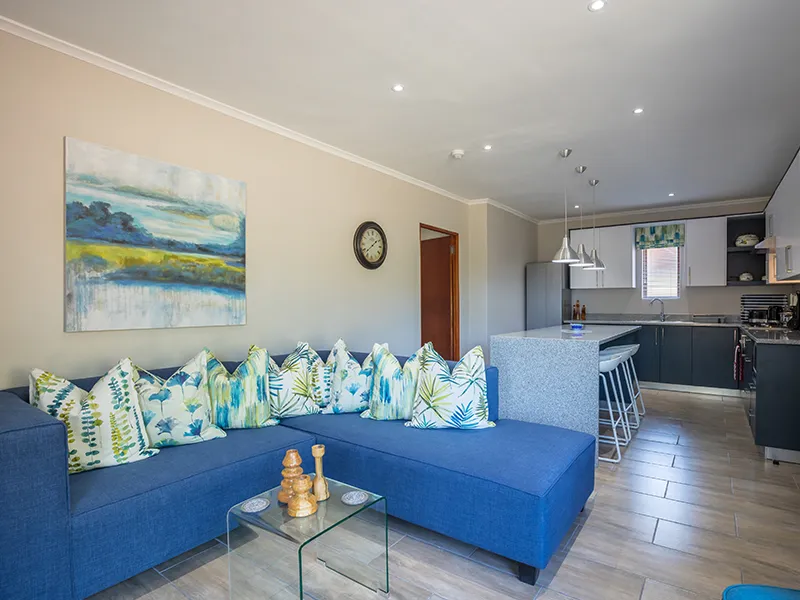 Blue sofa with patterned cushions in a modern living and kitchen area