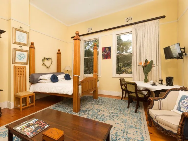 Cozy bedroom with fourposter bed seating area and large windows