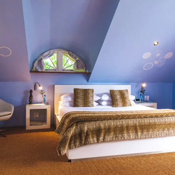 Bedroom with a large bed blue walls and circular wall decorations