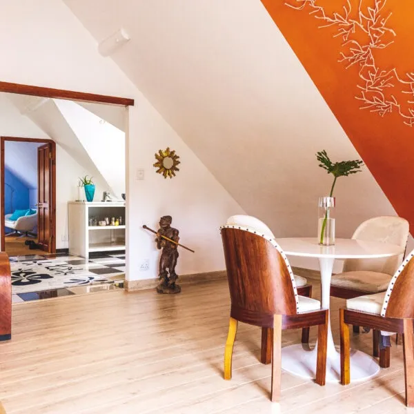 Wooden dining set in a modern slopedceiling room with decorative wall