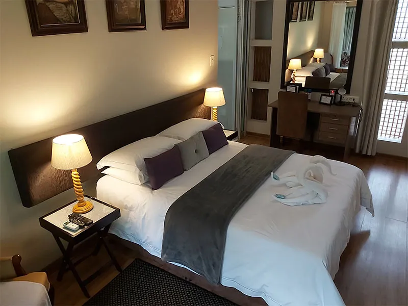 Cozy bedroom with a large bed bedside lamps and wooden flooring