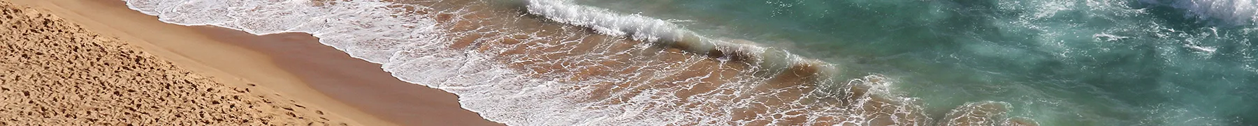 Beach with waves crashing onto the shore people scattered on the sand