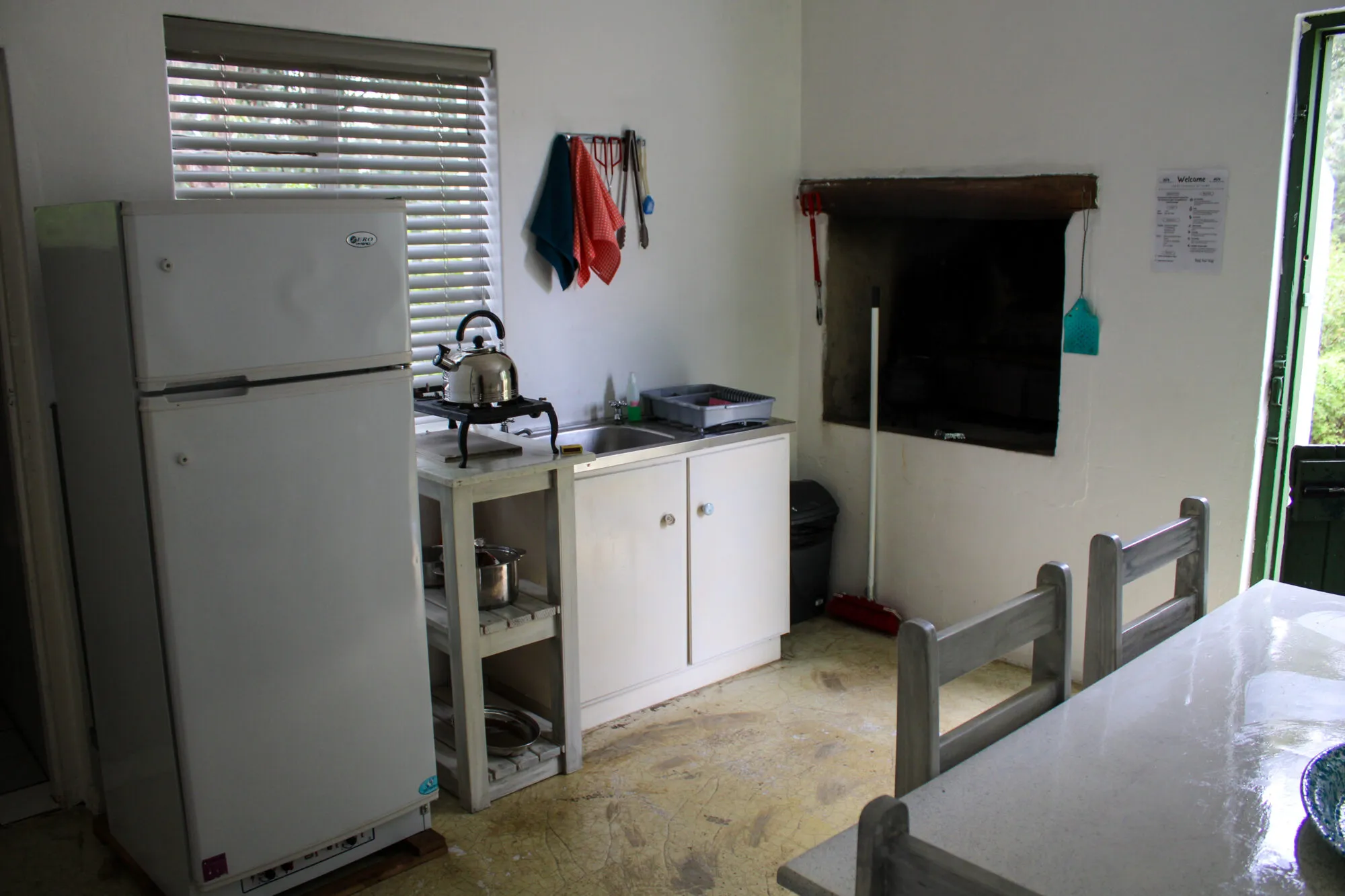 Small kitchen with white fridge cabinets and a builtin fireplace