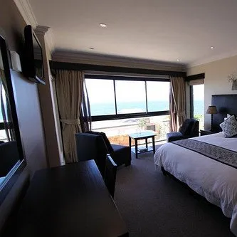 Bedroom with large windows ocean view and modern furniture