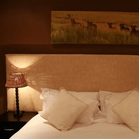 Bedroom with a bed lamp and a painting of animals on the wall