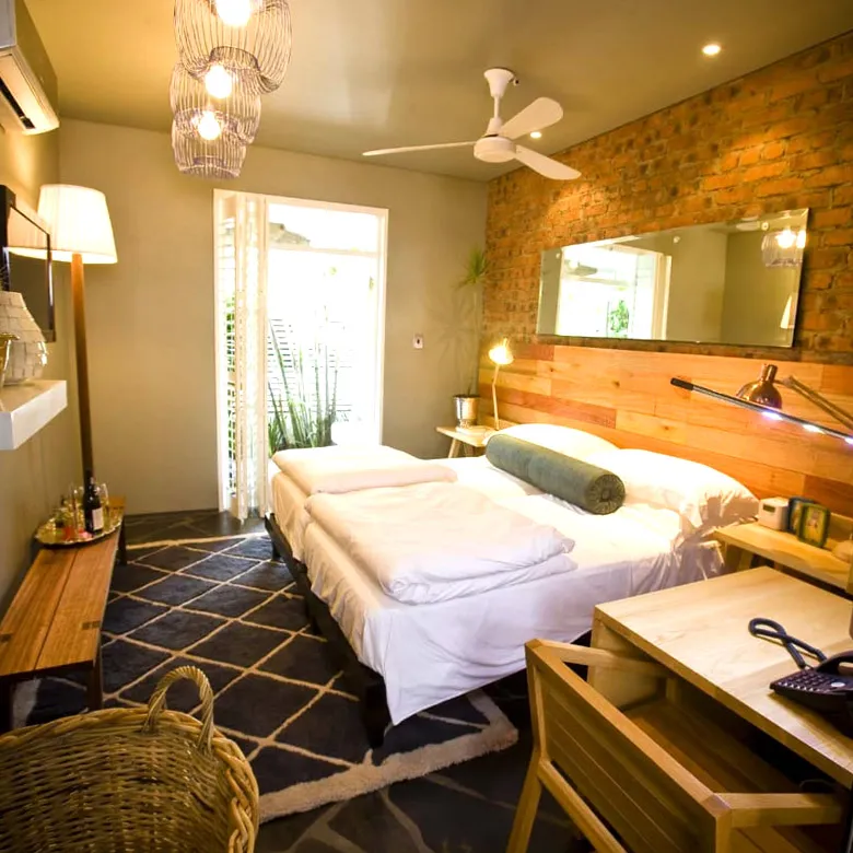 Cozy bedroom with a large bed wooden desk and brick wall decor