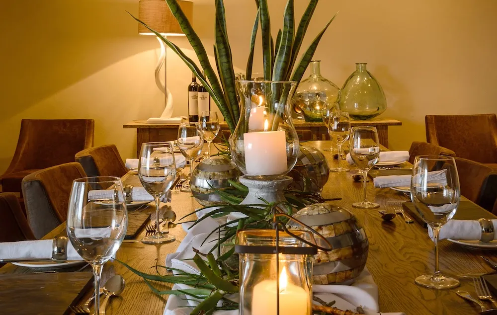 Elegant dining table set with candles plants and glassware in a cozy room