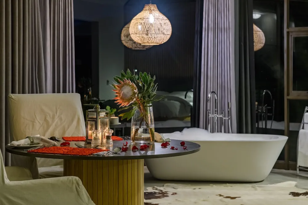 Cozy room with a round table bathtub and hanging lights at night