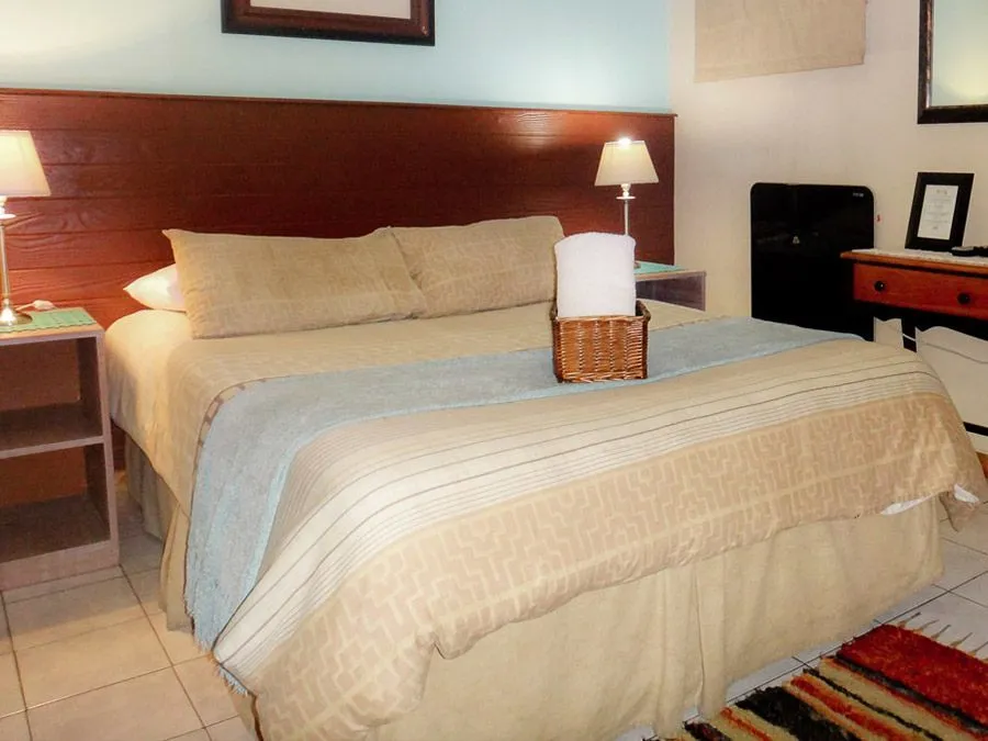 Bedroom with a neatly made bed side tables and a dresser