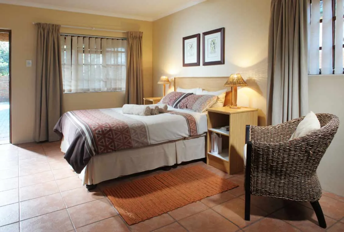 Cozy bedroom with a double bed nightstand and wicker chair